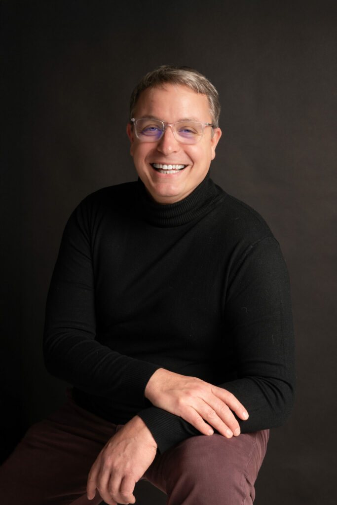 Portrait d'un homme souriant en pull noir