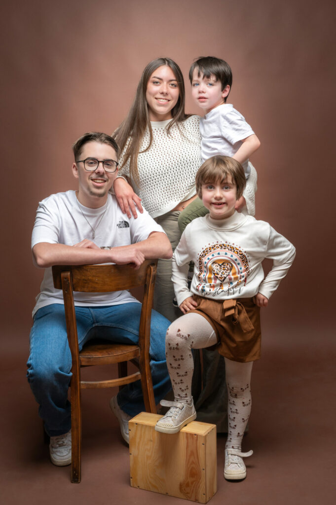 Couple et leurs deux enfants assis sur des cubes en bois