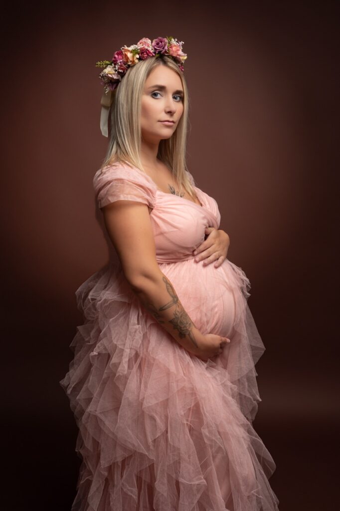 Future maman en robe rose et couronne de fleurs