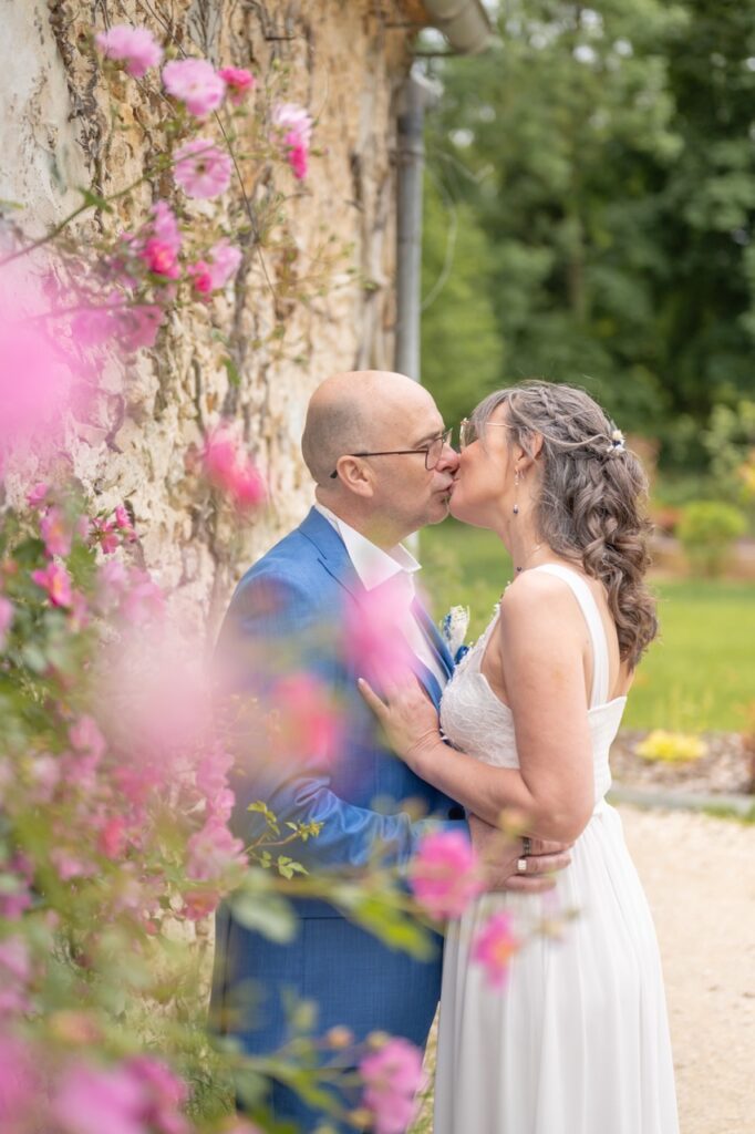Baiser des mariés au milieu des roses