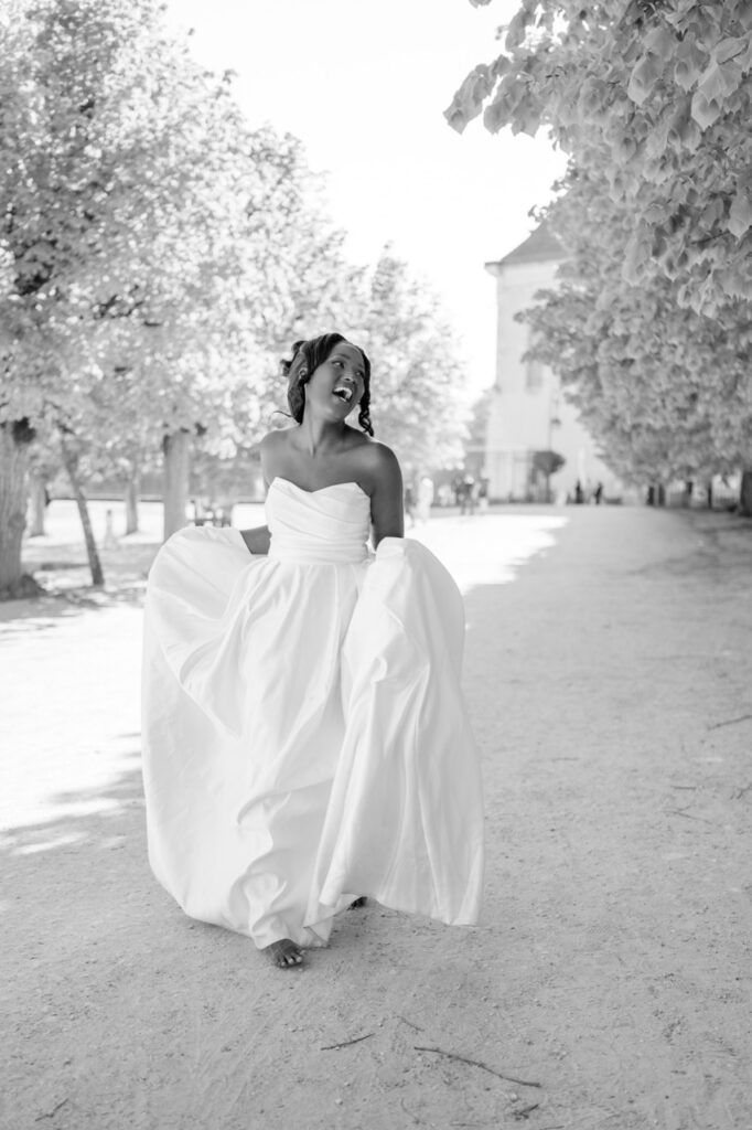 La mariée marche dans une allée arborée