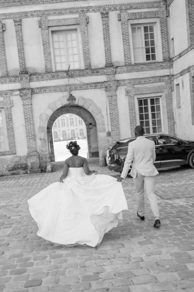 Les mariés traversent la cour d'un château