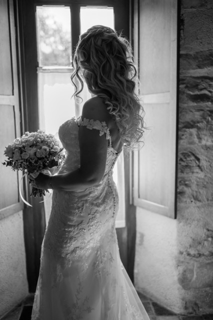 Mariée avec son bouquet à la fenêtre, noir et blanc
