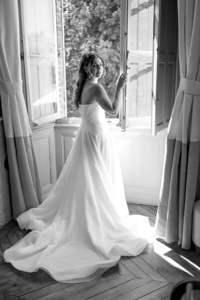 Mariée en robe devant une fenêtre, lumière naturelle