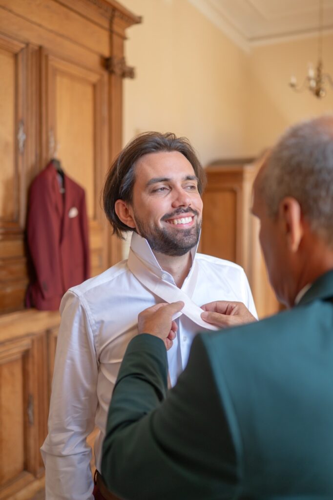 Le marié ajuste sa cravate avec un proche