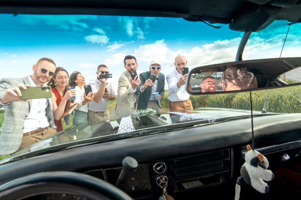 Les invités vus à travers le pare-brise de la voiture des mariés