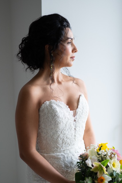 Portrait de la mariée avec son bouquet près de la fenêtre