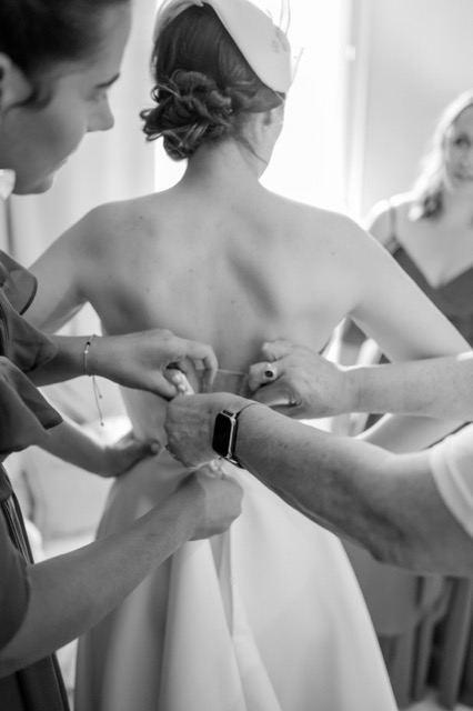 La mariée se fait lacer sa robe le matin du mariage
